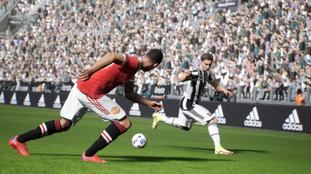 A juventus player runs and tries to dribble a manchester united player in eFootball 2022