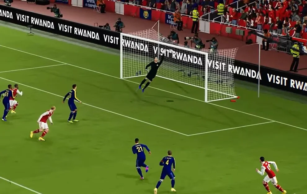 Goalkeeper tries to punch away the ball while center backs run in eFootball 2023